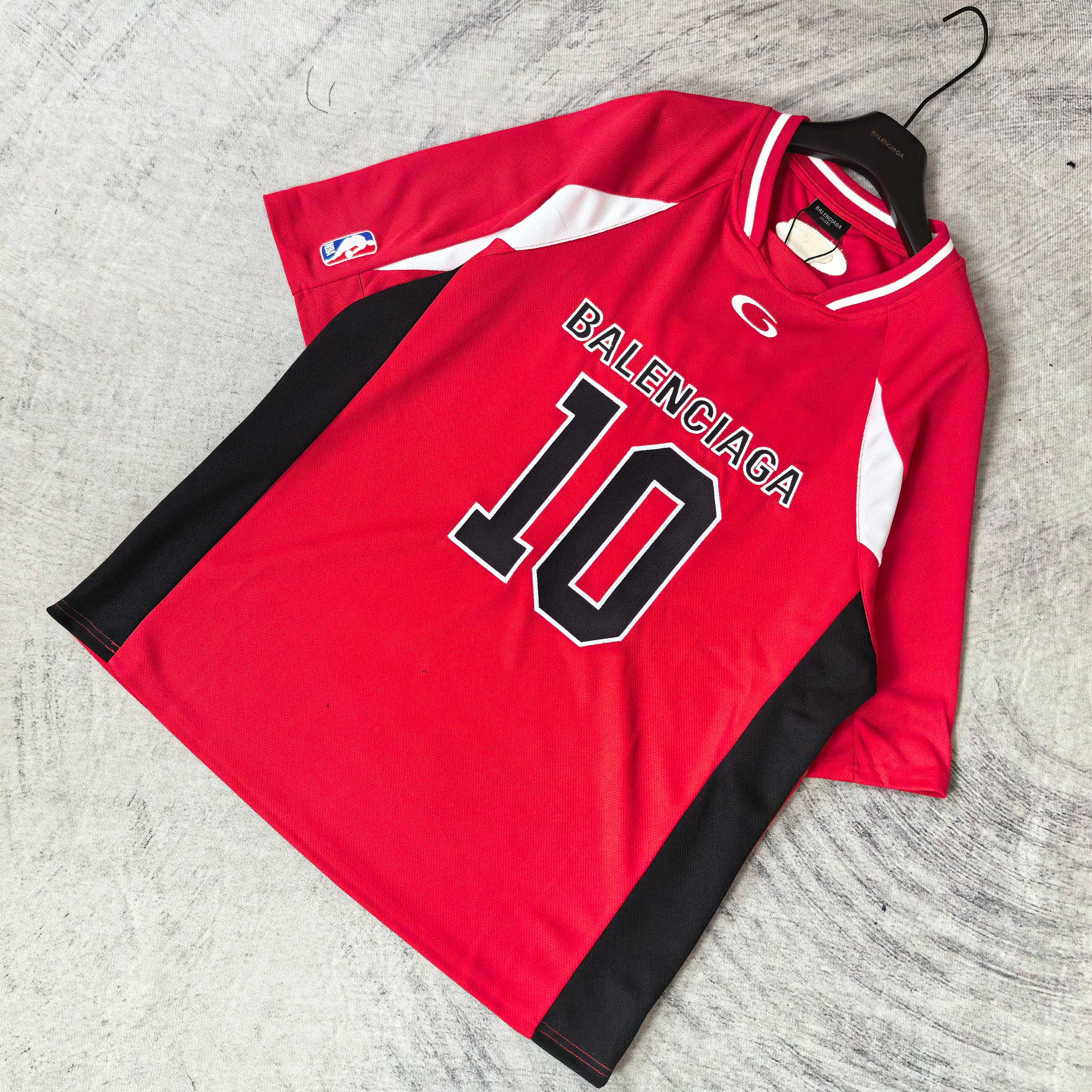 Red short-sleeve jersey laid flat with BALENCIAGA 10 front print and black side panels