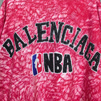 Balenciaga T-shirt print close-up: BALENCIAGA text and NBA emblem on red