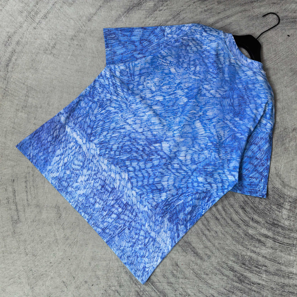 Blue short-sleeve graphic T-shirt, laid flat with crew neck and all-over pattern.