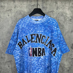 Blue short-sleeve graphic T-shirt with Balenciaga and NBA logo front, crew neck.