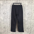 Black track pants with elastic waistband, relaxed straight legs