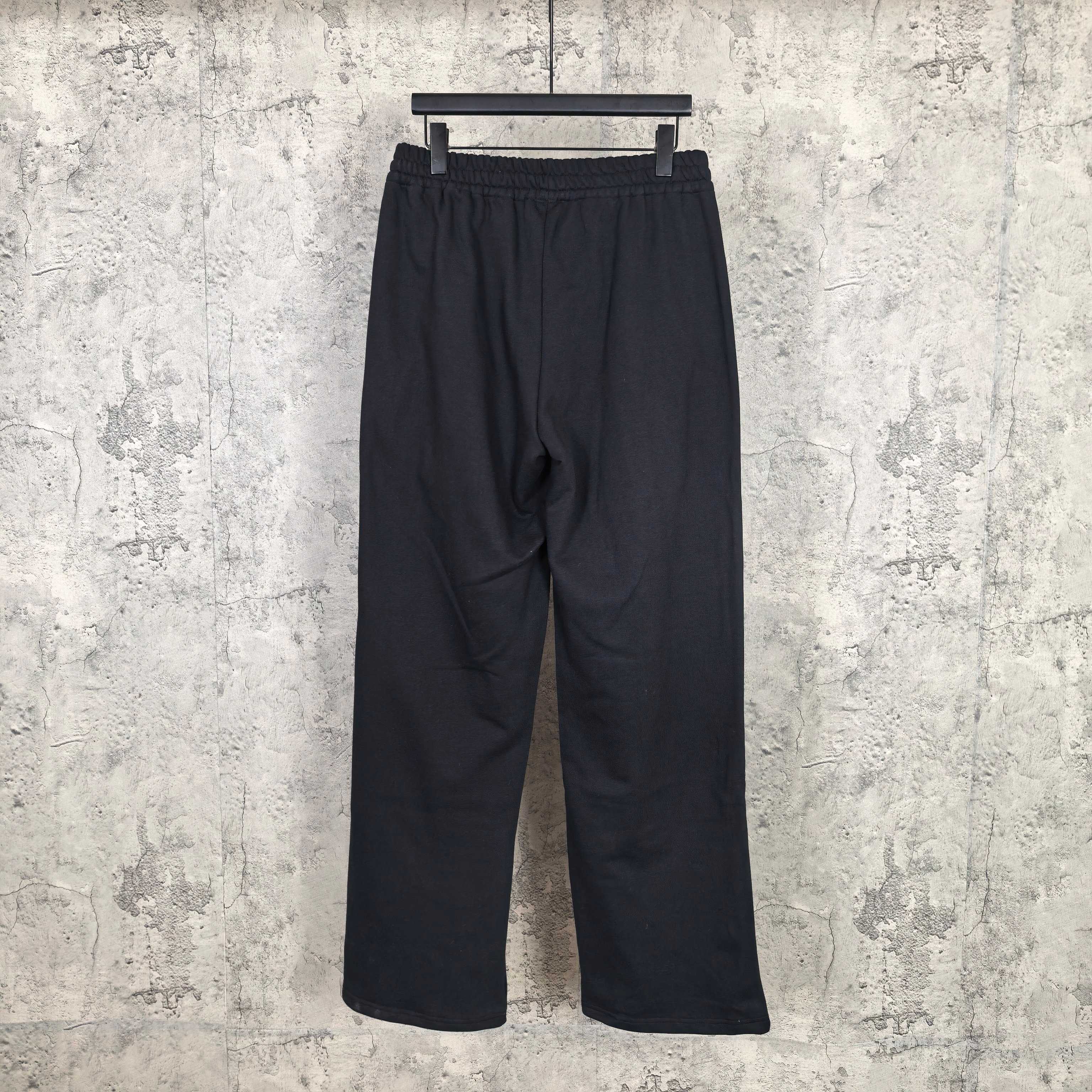 Black track pants with elastic waistband, relaxed straight legs