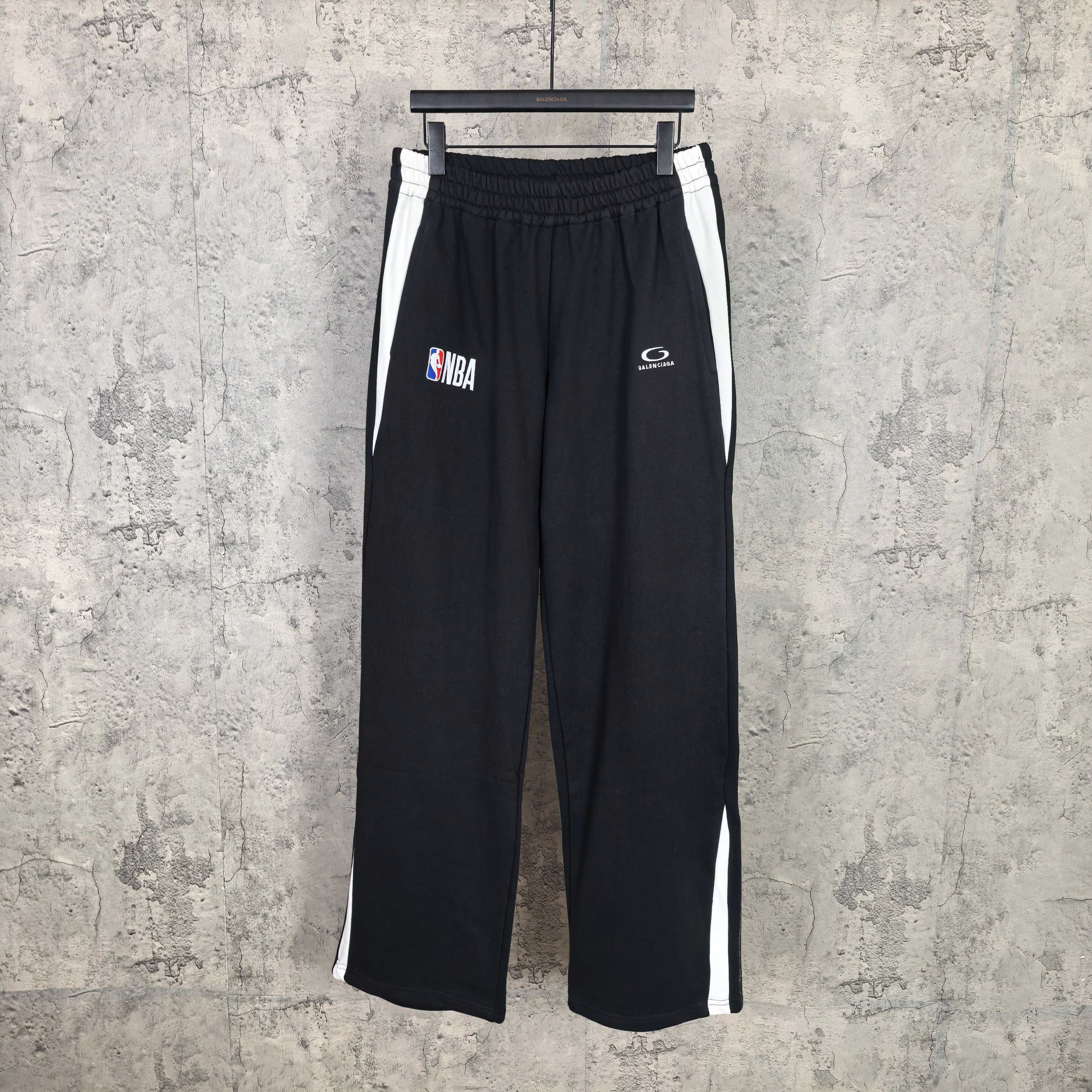 Black track pants with elastic waistband and side white stripe