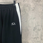Black track pants with white side stripe and Balenciaga logo near thigh