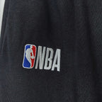 Close-up of NBA logo patch on black track pants