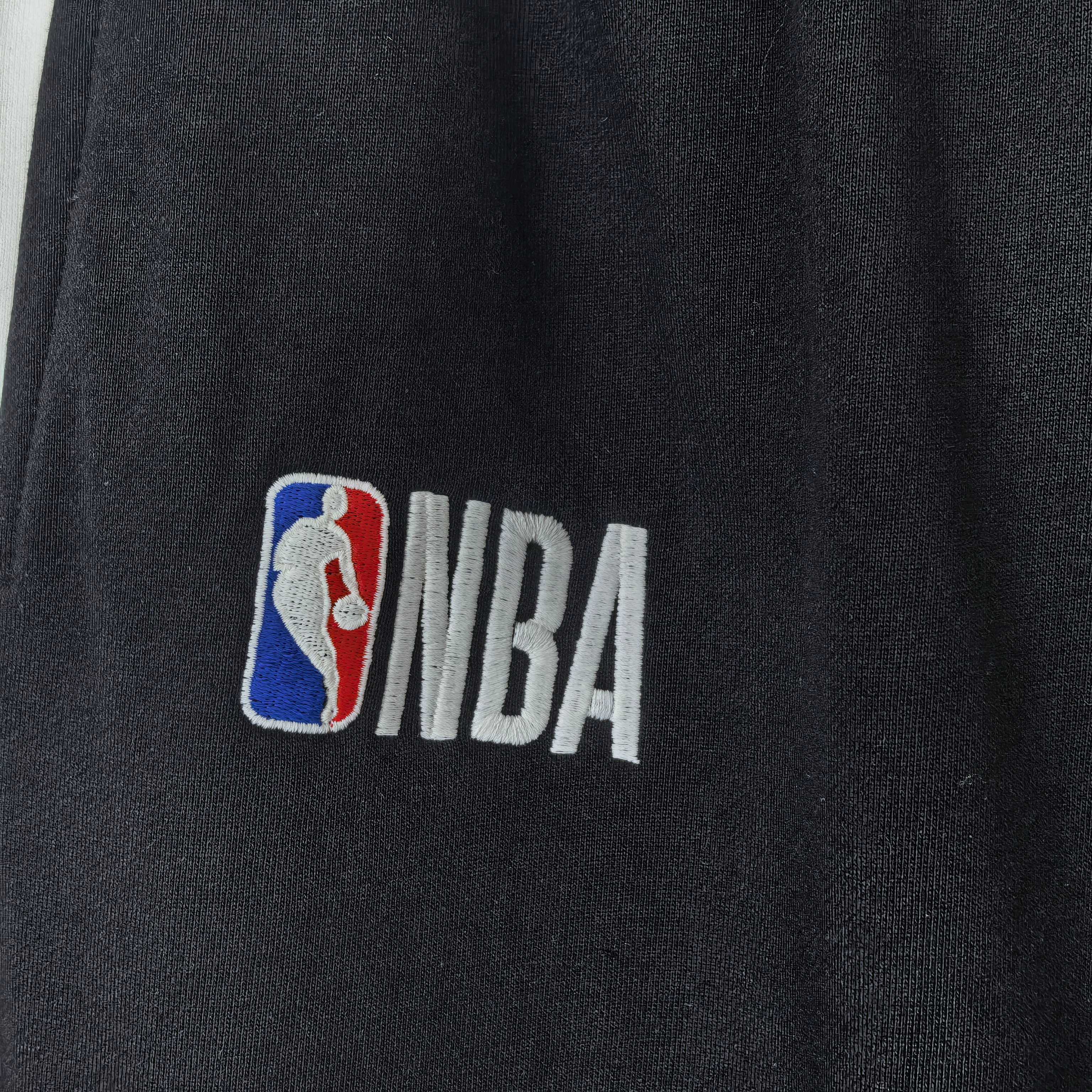 Close-up of NBA logo patch on black track pants