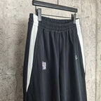 Black track pants with elastic waistband, side stripe, NBA logo