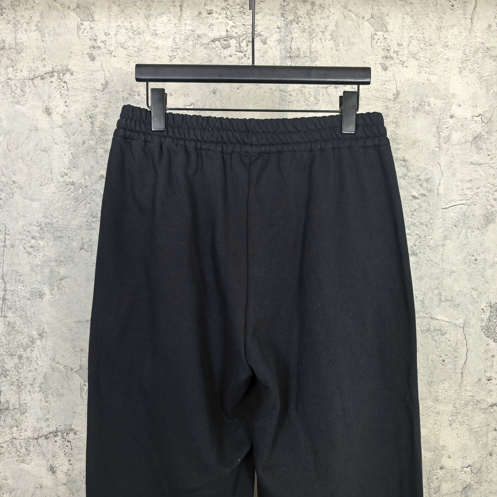 Black track pants with elastic waistband and textured fabric surface
