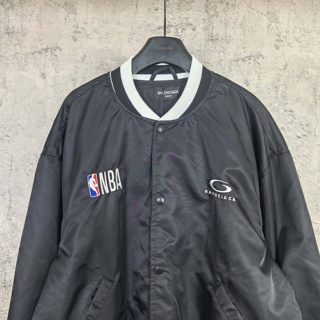 Black varsity bomber jacket with white-trim V-neck collar and NBA patch