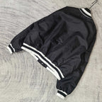 Black varsity bomber jacket with white stripe detailing at hem and cuffs
