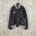 Black varsity bomber jacket with white striped ribbed cuffs and NBA patch