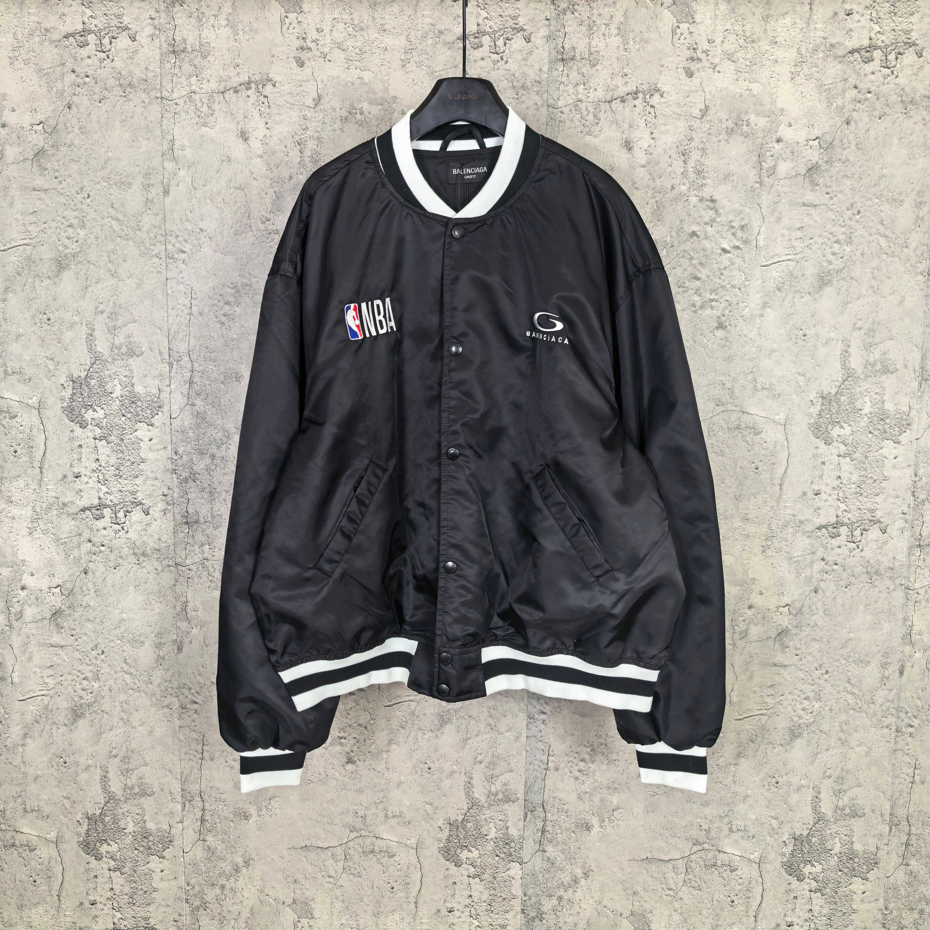 Black varsity bomber jacket with white striped ribbed cuffs and NBA patch