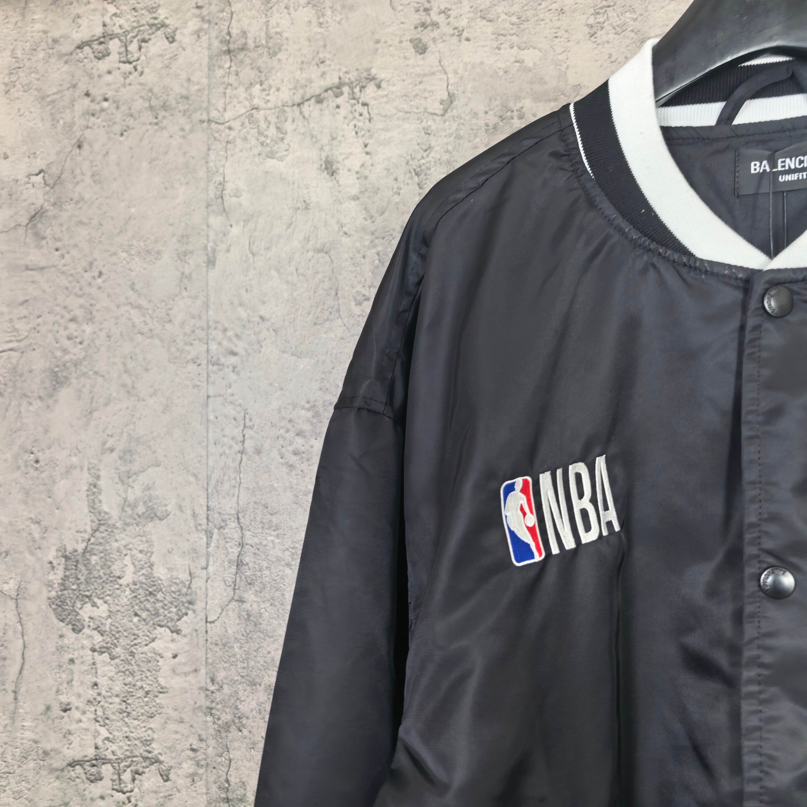 Black bomber jacket with NBA patch on chest and white-trim V-neck collar