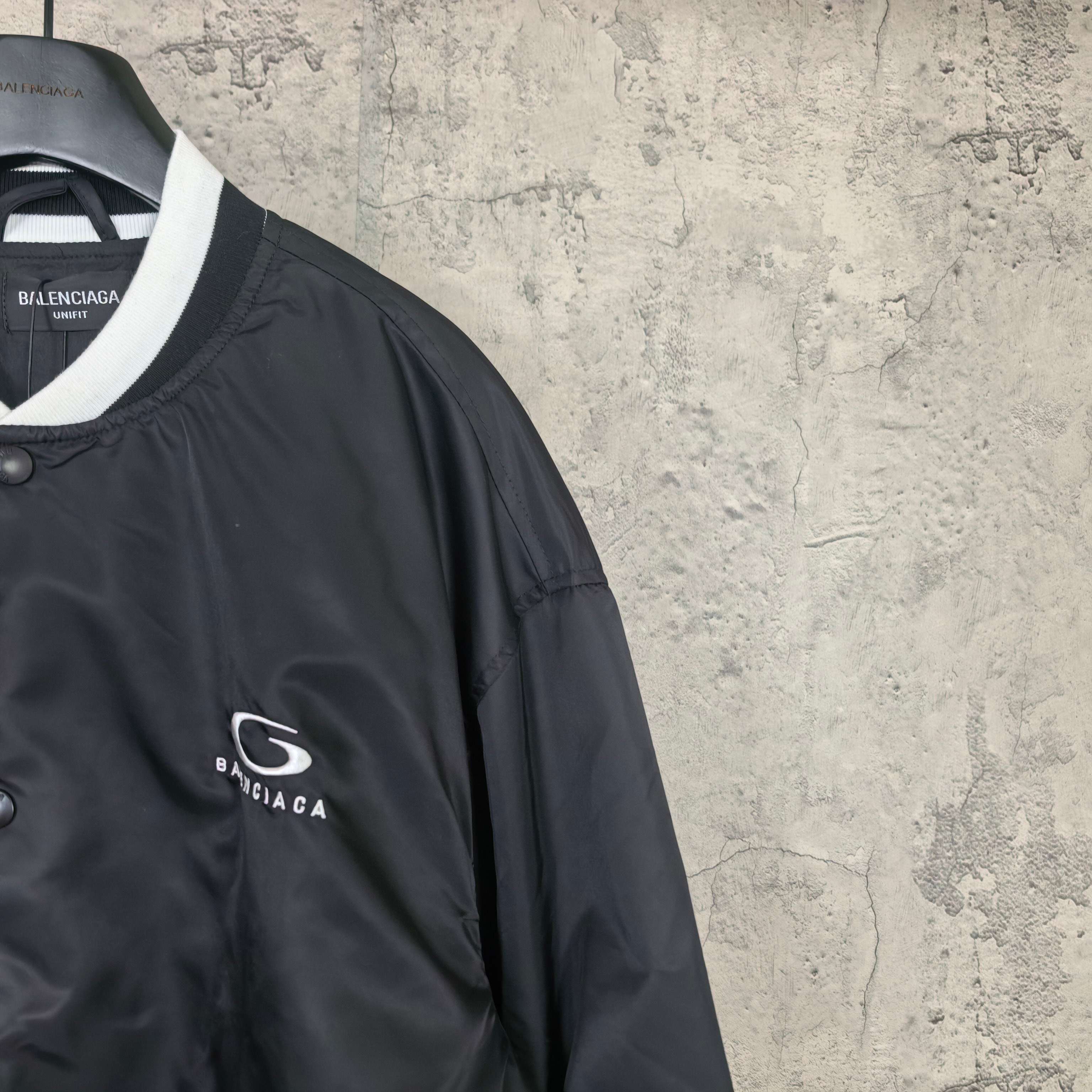 Black bomber jacket with Balenciaga logo patch on sleeve and white collar trim