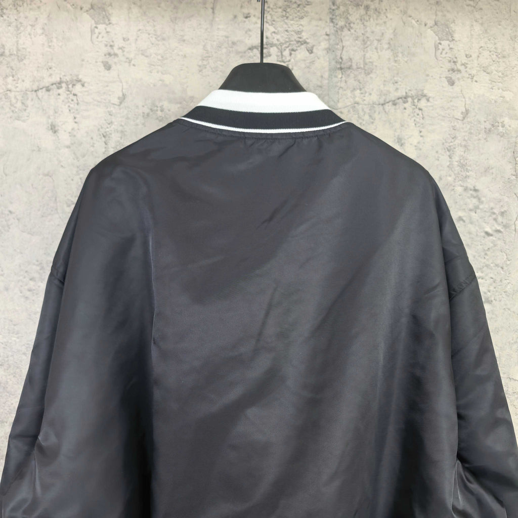 Black varsity bomber jacket, plain back view with ribbed white collar trim