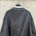 Black varsity bomber jacket, plain back view with ribbed white collar trim