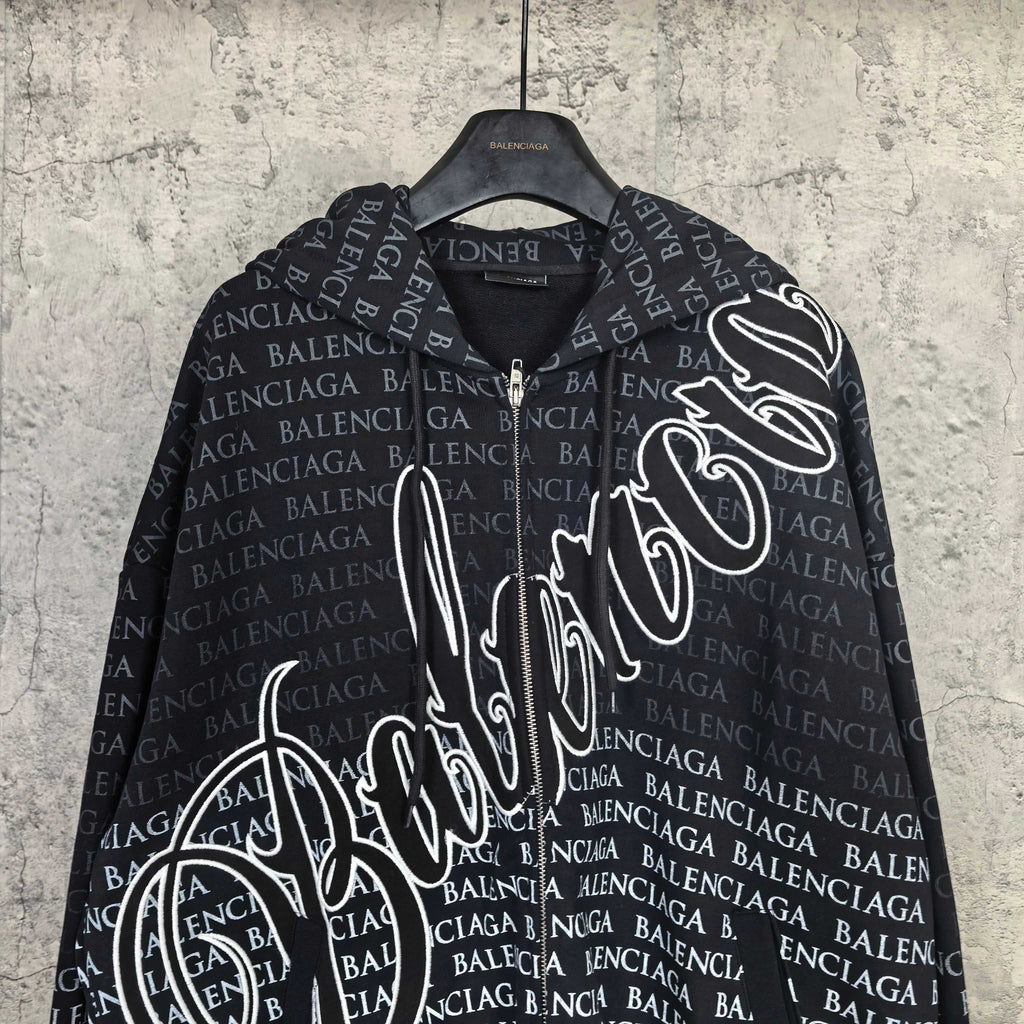 Balenciaga zip-up hoodie close-up, black with repeating text and bold white script logo