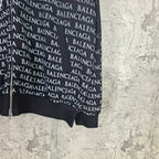 Lower front close-up of dark zip hoodie with Balenciaga text pattern and hem cuff.
