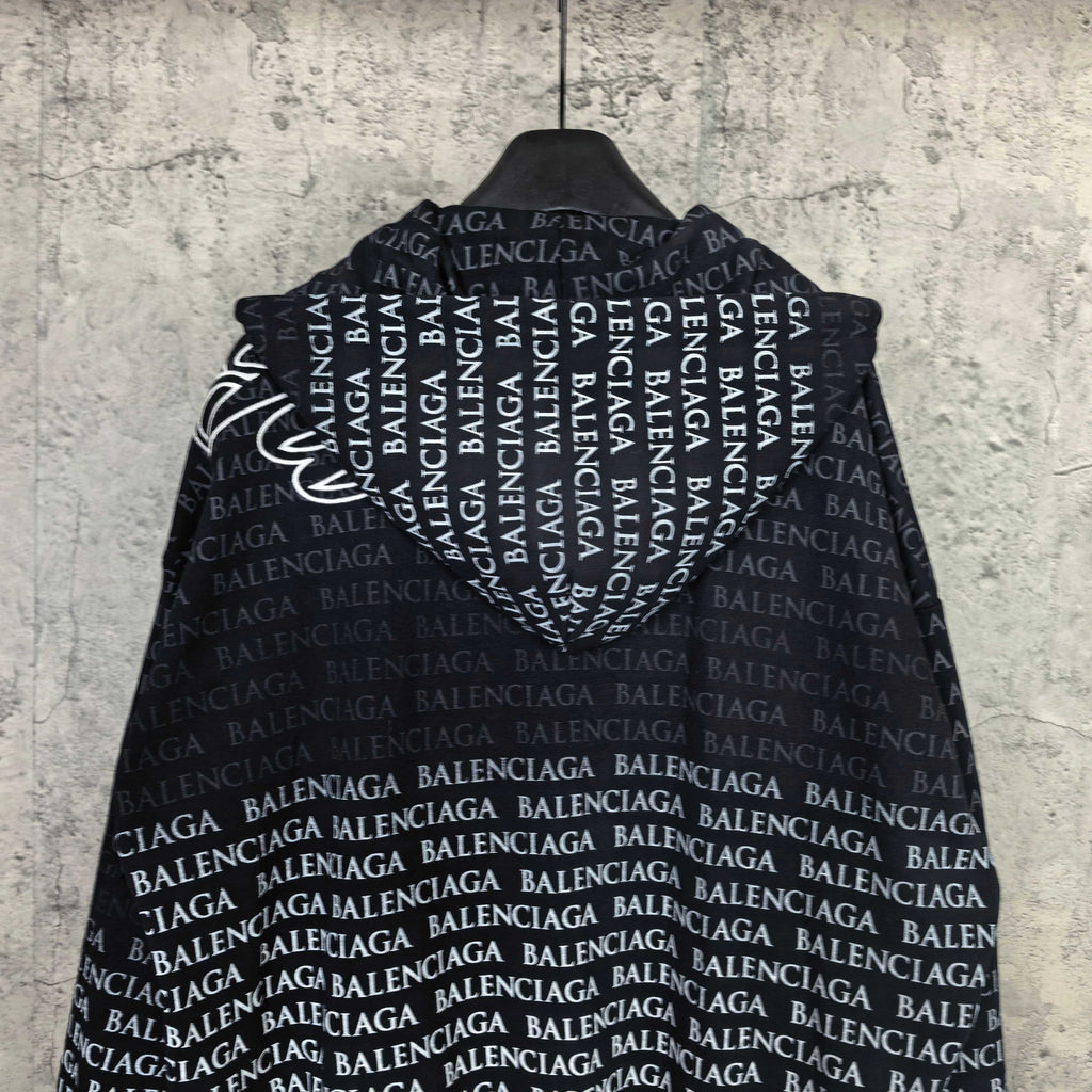 Back of dark long-sleeve zip hoodie with repeating Balenciaga text pattern.