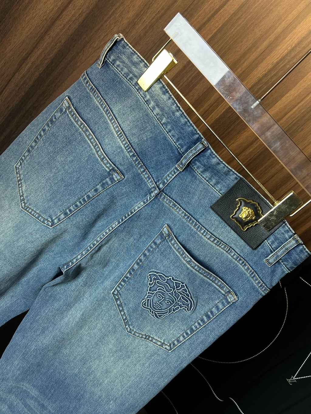 Versace light-wash denim jeans with gold crest patch and embroidered front pocket