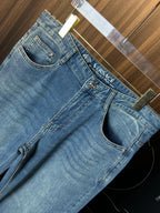 Versace denim jeans close-up with VERSACE label on waistband and stitched pocket design