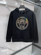 Dark hooded sweatshirt with drawstrings and large circular Medusa rhinestone print