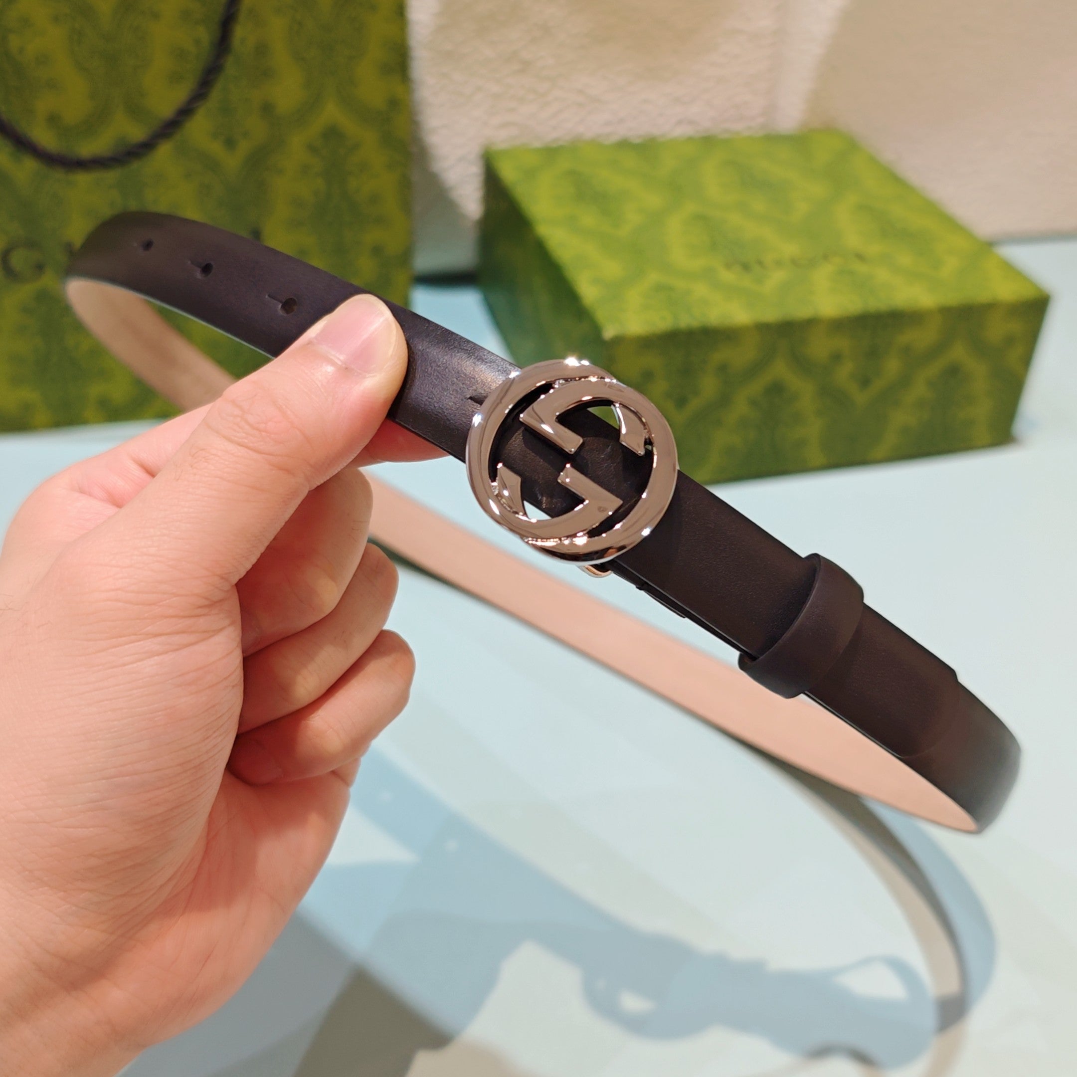 Gucci belt in dark brown leather with silver-tone interlocking GG buckle.