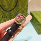 Gucci belt with dark brown leather strap and silver-tone GG buckle face close-up.
