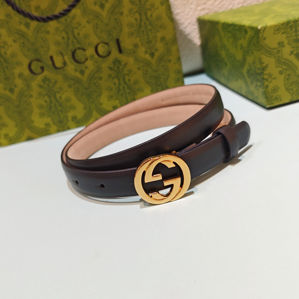 Gucci belt with gold-tone GG buckle on dark leather strap, curved view
