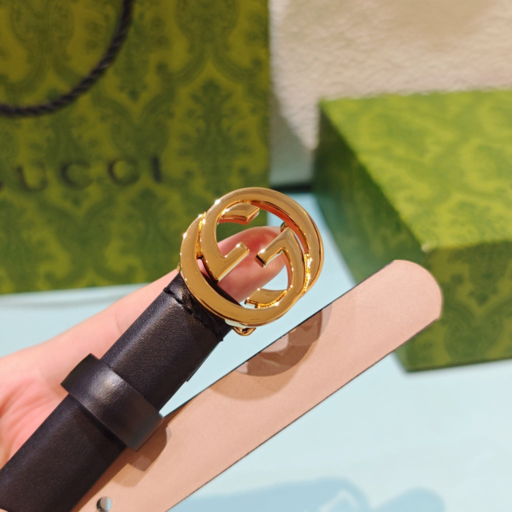 Gucci belt with gold-tone GG buckle and dark leather strap, close-up