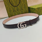 Brown leather belt with large silver double-G buckle and punched holes