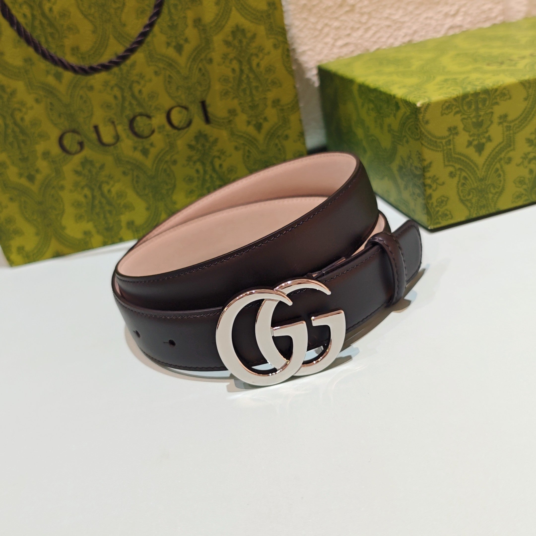 Brown leather belt with curved silver double-G buckle