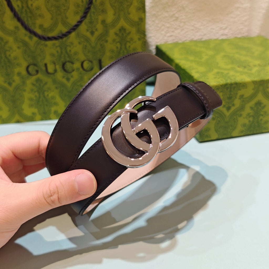 Dark brown leather belt with silver double-G buckle, close-up clasp