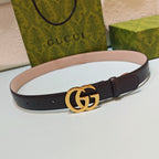 Gucci belt with dark strap, gold GG buckle, and light inner side