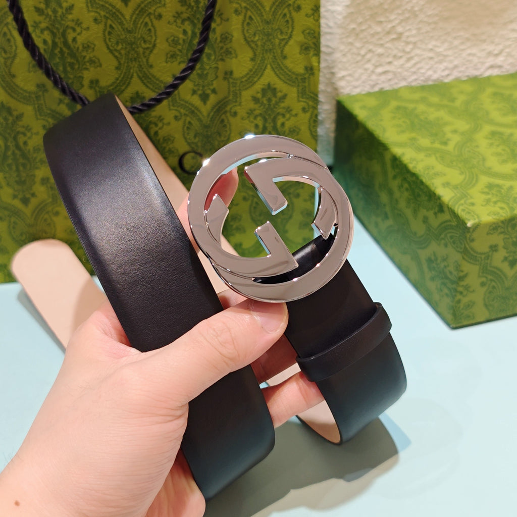 Dark leather belt with GG buckle close-up in silver-tone metal