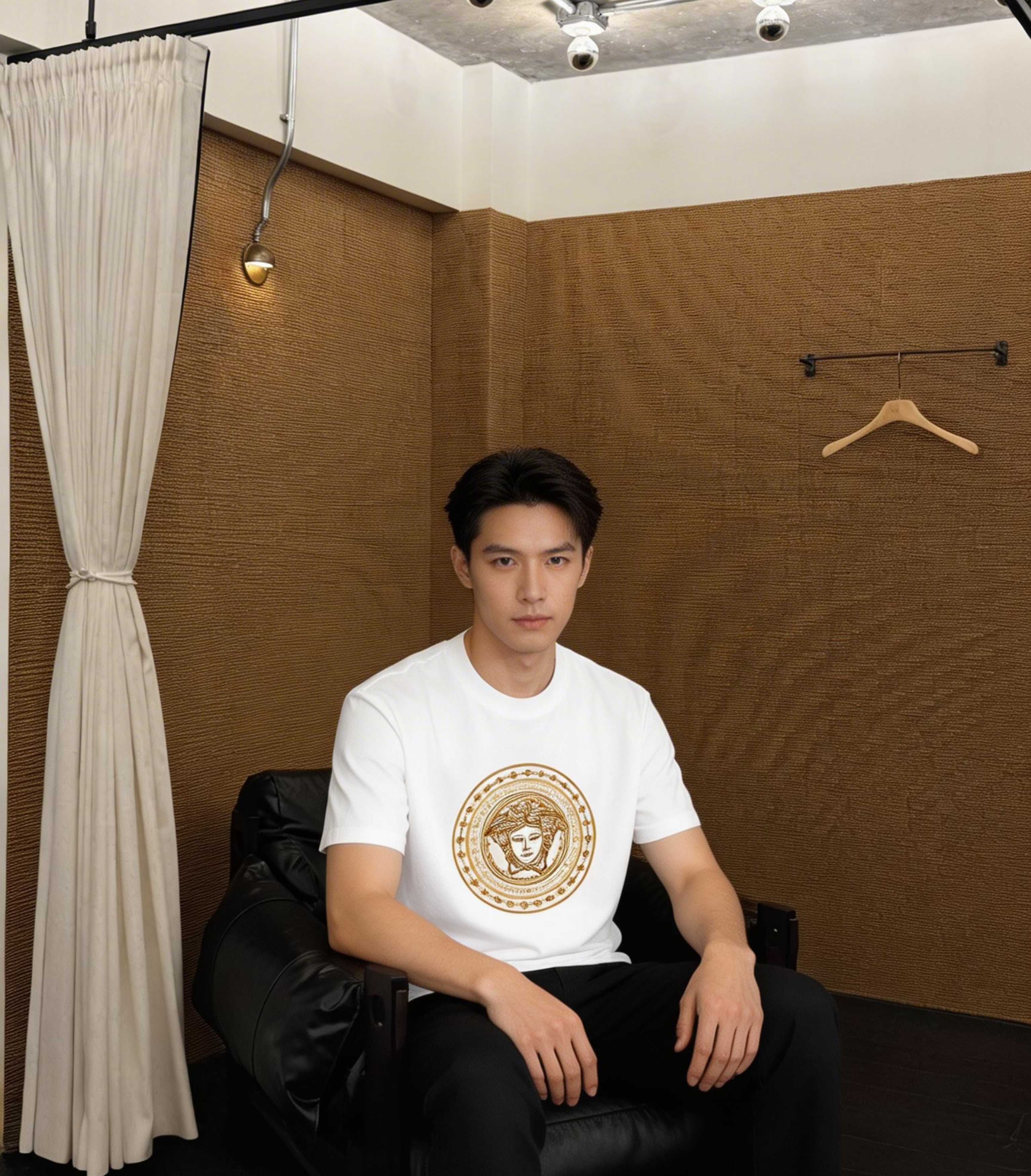 Versace white T-shirt worn by a model, featuring a gold circular Medusa graphic
