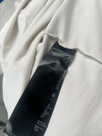 Black fabric care label tag inside white short-sleeve T-shirt