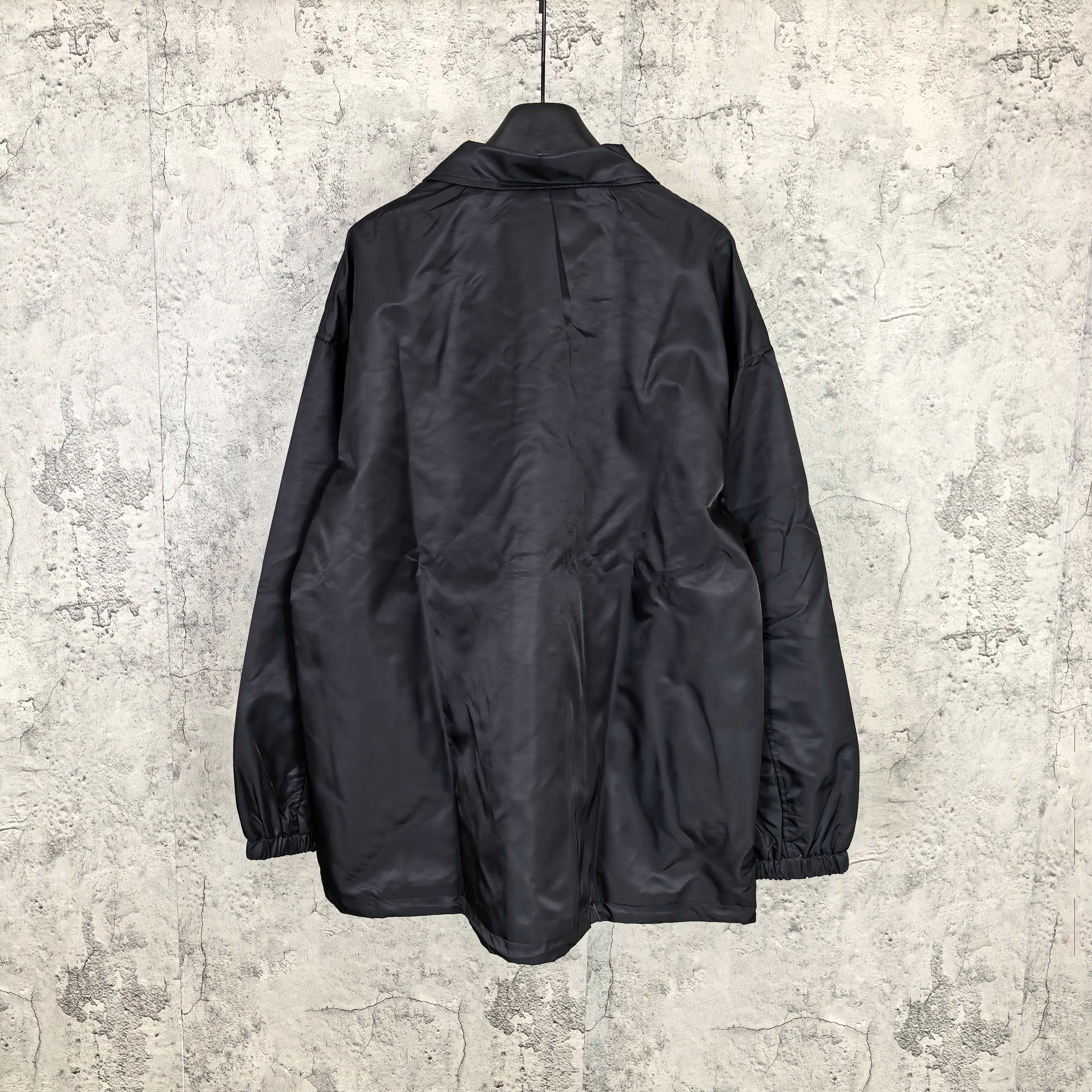 Dark navy long-sleeve jacket back view with button placket and elastic cuffs
