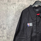 Dark navy jacket shoulder with NBA patch, button placket and red inner collar