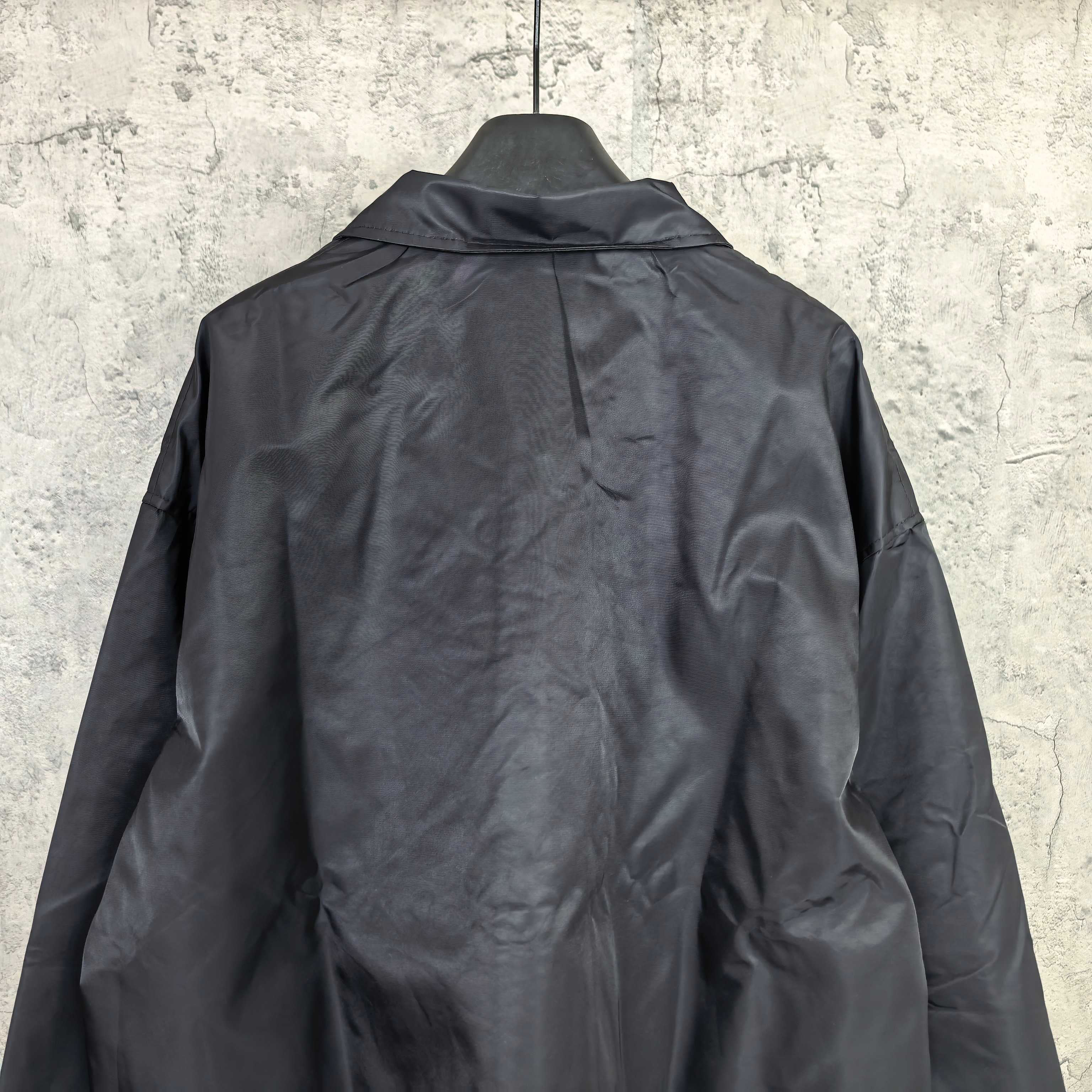 Dark navy long-sleeve jacket with raised collar and full back panel