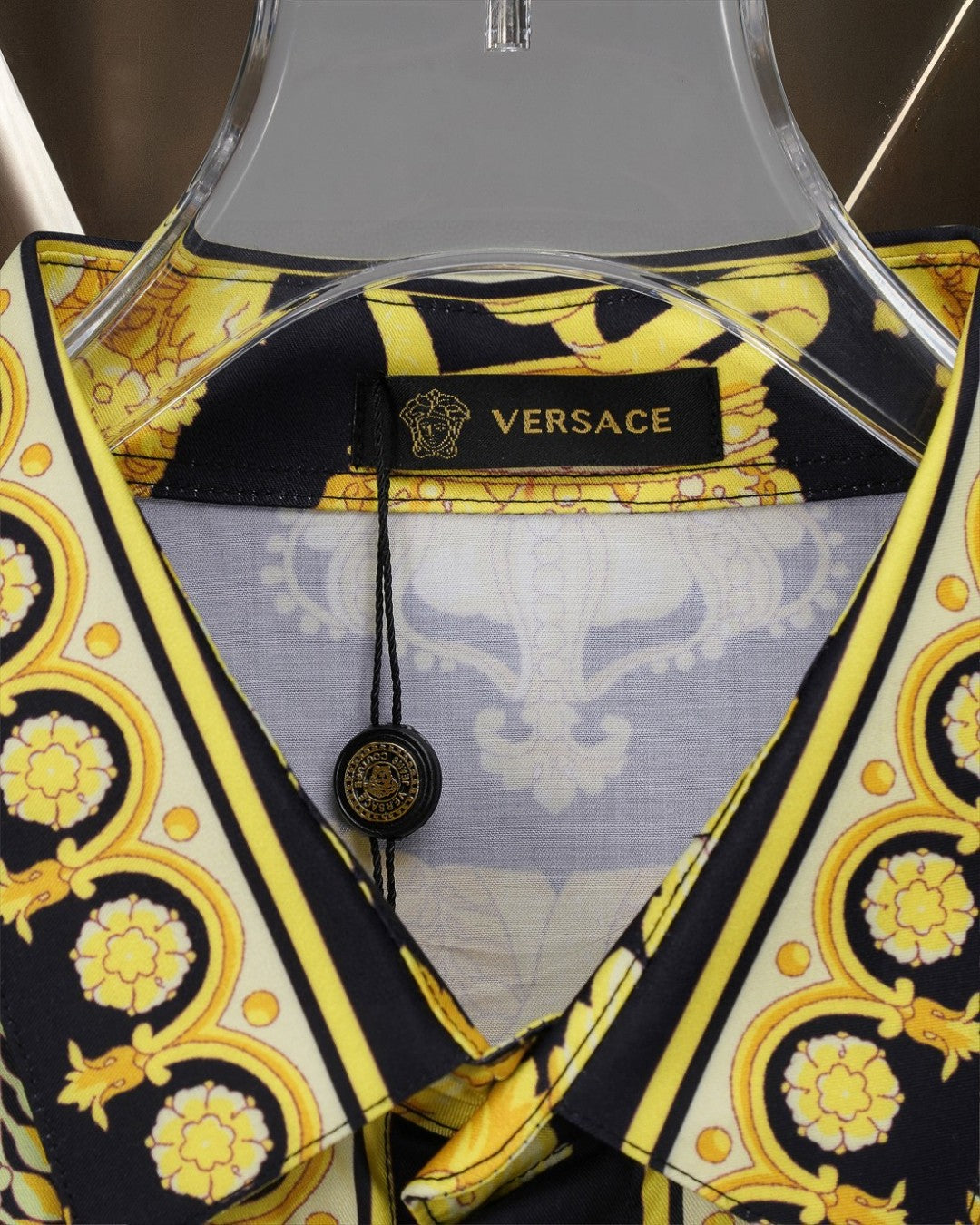 Versace shirt neckline close-up, gold trim and baroque print on black
