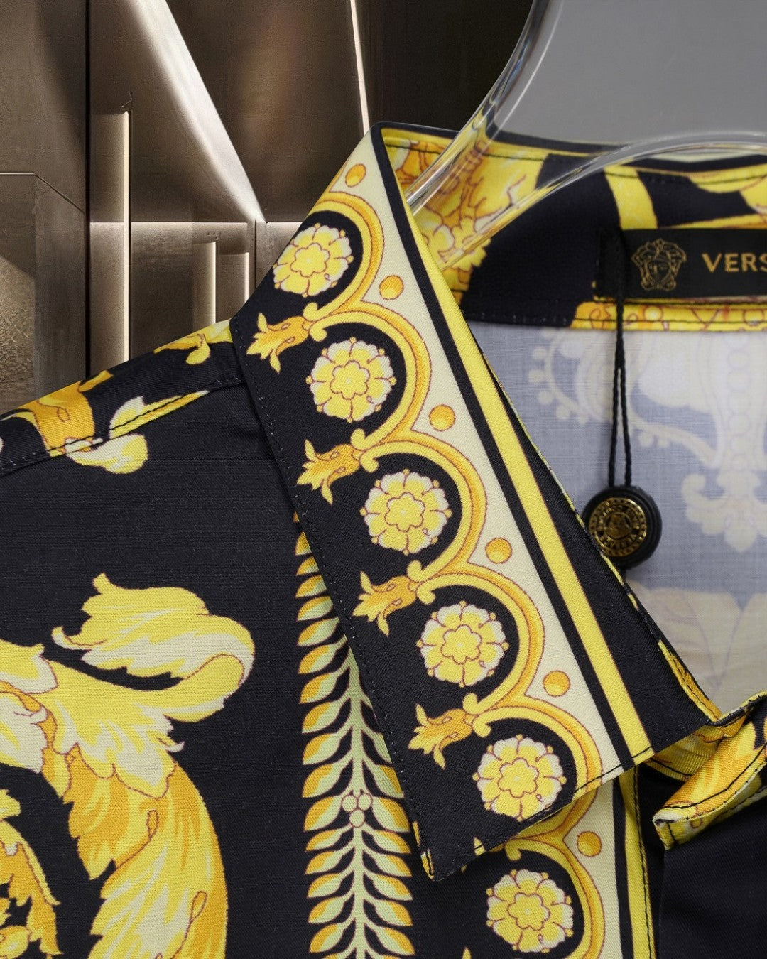 Versace shirt sleeve close-up, black with gold baroque border and rosette motifs