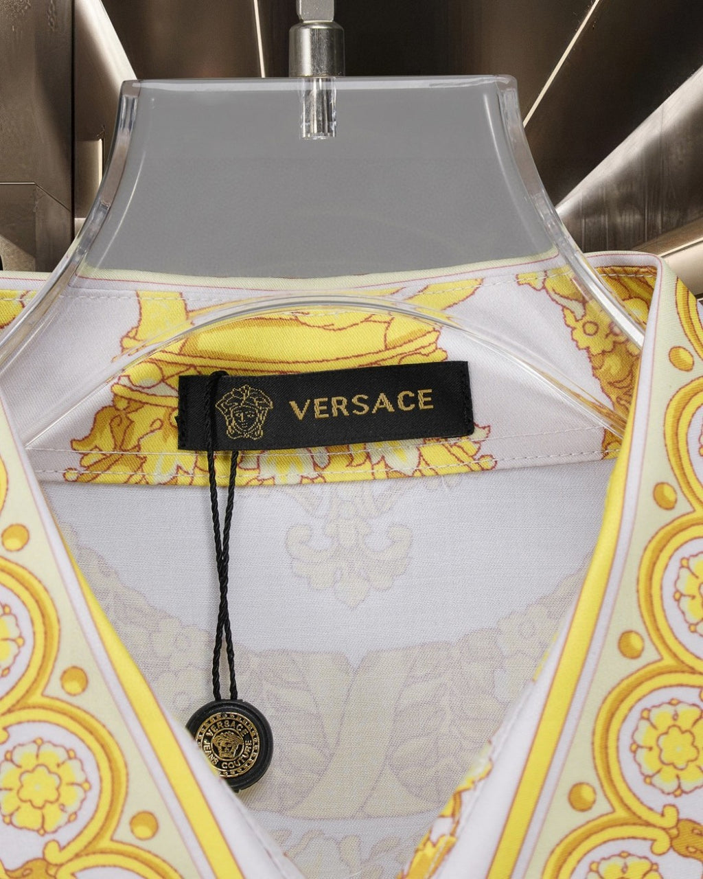 Versace shirt neckline detail with white fabric, yellow print, and brand label