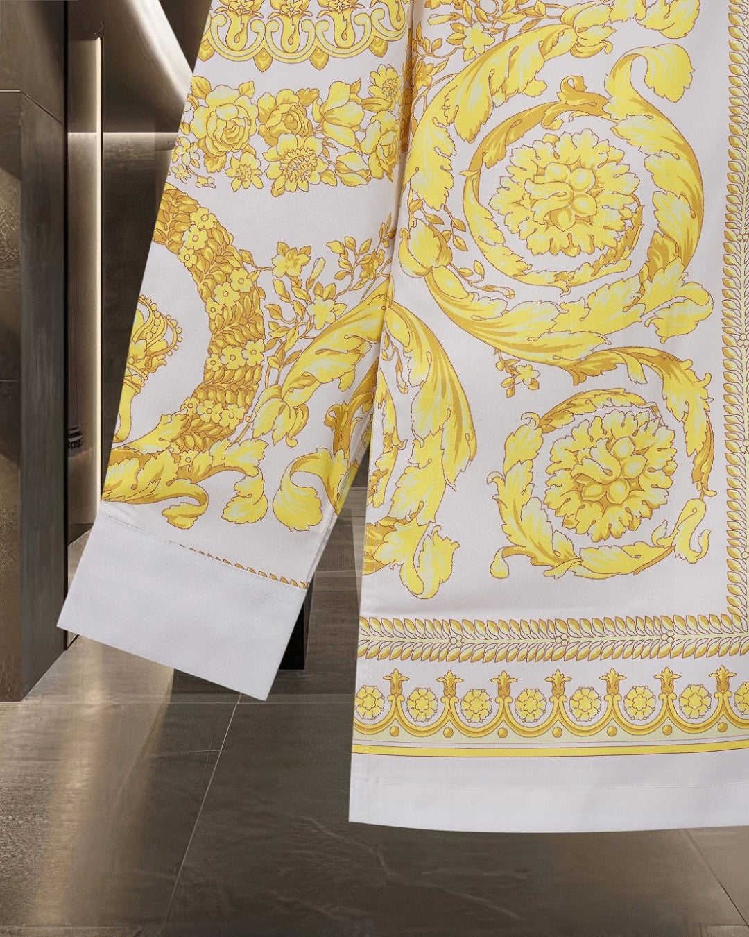 Versace shirt side view with yellow baroque print and patterned hem border