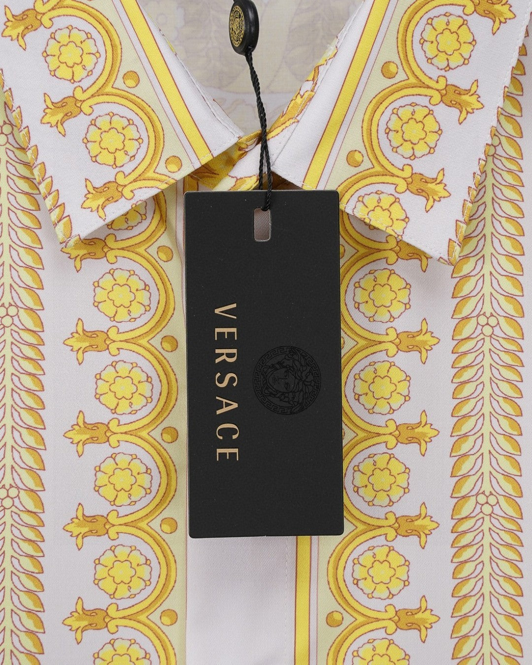 Versace shirt hanging tag on collar placket; yellow baroque print on white fabric