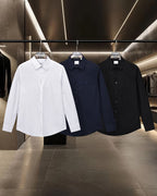 Burberry long-sleeve button-up shirts in white, navy, and black