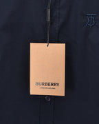 Burberry London England hangtag on navy button-up shirt