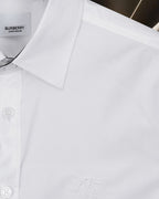 White long-sleeve button-up shirt with embroidered logo at chest