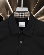 Black button-up shirt with pointed collar and visible front buttons; Burberry label