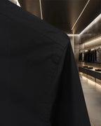 Black shirt side seam and shoulder detail with buttoned cuff